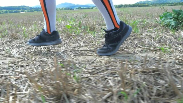 Female legs in compresion running socks. Woman in sportswear running along the field.