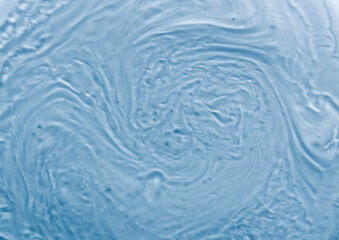 Full frame background liquid texture. Waves and swirls of gel like substance. Blue tone with tiny...