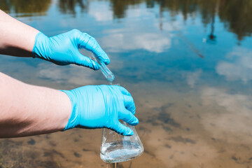 ecologist takes water in a test tube from a lake, river, sea. The concept of ecology