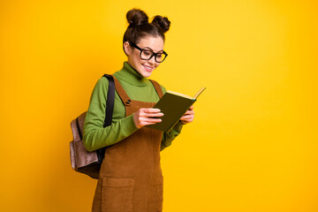 Portrait of her she nice attractive cheerful focused intelligent funky girl nerd geek reading interesting book courses club isolated bright vivid shine vibrant yellow color background