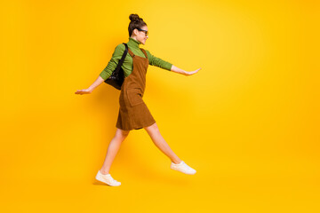 Fototapeta na wymiar Full length body size profile side view of her she attractive cheerful smart clever girl nerd jumping going back to school attending courses isolated bright vivid shine vibrant yellow color background