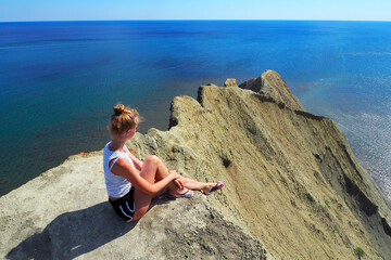A young lady is sunbathing on a high beach. Crimea. Cape Chameleon