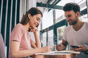 Colleagues discussing ideas and taking notes in cafe