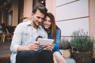 Happy couple cuddling and using tablet