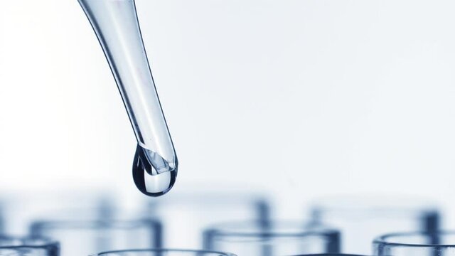 Closeup shot of scientist dripping liquid into test tube with rotating
