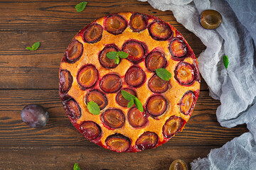 Delicious homemade plum pie on rustic background. Top view