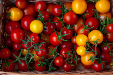 Red and yellow cherry tomatoes top view. Harvest vegetables. Tomato on the table. Vitamin healthy food. Rustic kitchen