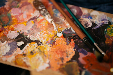 Close up of painting spatula covered with paint.