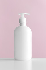 White cosmetic liquid soap dispenser bottle mockup with pink background.