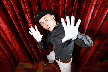 Young caucasian man in black bowler hat  with funny face and white gloves posing like master of...