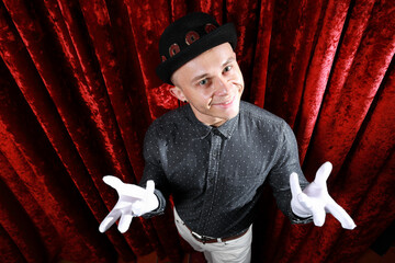 Young caucasian man in black bowler hat  with funny face and white gloves posing like master of...