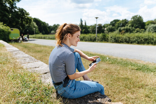 Young woman relaxing alongside a rural road