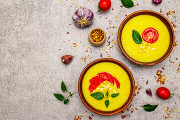 Corn cream soup with fresh vegetables, herbs and spices