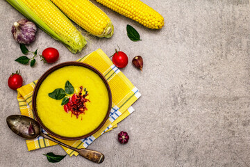 Corn cream soup with fresh vegetables, herbs and spices