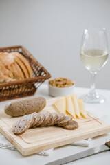 Queso de cerdo codeguín en tabla de madera con quesos y pan, acompañado de vino blanco