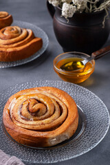 Freshly baked cinnamon buns with honey on a plate. Pastry