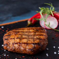 Beef steak on a black stone. Closeup