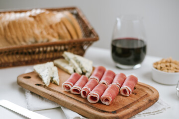 jamón crudo en tabla con queso azul y vino tinto