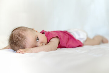 Caucasian baby girl as he lays on bed