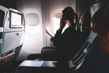 Fototapeta premium Woman listening to music in headphones during flight