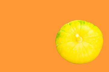 Yellow pumpkin on a orange background. Happy Halloween. New crop concept. Isolate, copy space. Top view.
