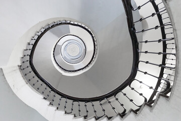 Black and white round spiral staircase with black railings with patterns top view