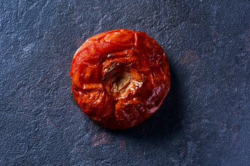 roasted tomato on a black stone surface