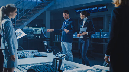International Team of Automobile Design Engineers Introducing Futuristic Autonomous Electric Car Platform Chassis to Group of Investors and Businesspeople. Business Technology, Research and Investment