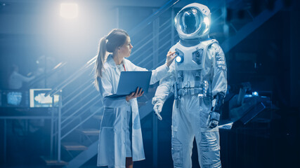 Shot of an Aerospace Scientist Wearing White Coat Use Computer for Designing New Space Suit Adapted for Galaxy and Travel Exploration. Constructing Astronaut Suit