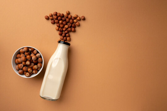 Hazelnut Vegan Milk In Bottle On Brown Background Top View