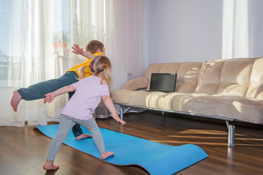 Brother and sister watching online fitness exercises at home. Kids sports, stay at home, online learning, online training.