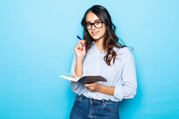 Young girl bought new planner, writing down notes or lecture, smiling joyfully, holding red...