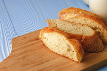 Sliced baguette bread on wooden board close up