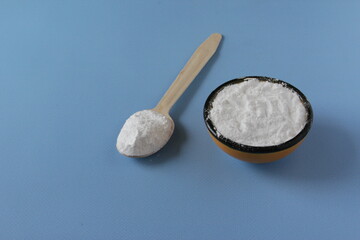 Collagen powder on blue background. Extra protein intake. Natural beauty and health supplement for skin, bones, joints and gut. Flatlay, top view. Copy space.