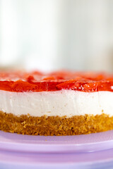 Side view close up of a home made cheesecake with strawberries. layers and layers of tasty deliciousness. Dessert.