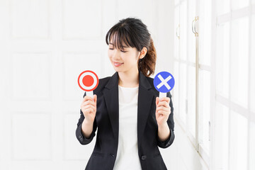 OKとNGのプラカードを持つ若いビジネスウーマン