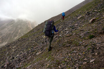 Fototapeta premium Mountain tourism. Tourists climb the mountain pass. Tourists climb the Shirman North Pass (3450 meters above sea level).