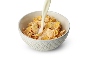Milk is poured into a bowl with muesli, isolated on white background