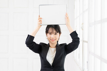 小さいスケッチブックを持つ若いビジネスウーマン