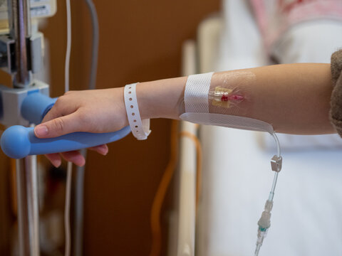 A patient's hand holding on to a handle for support