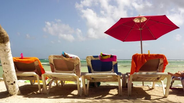 Sun chairs and the sun umbrella on a beautiful sandy bech somewhere in the Caribbean
