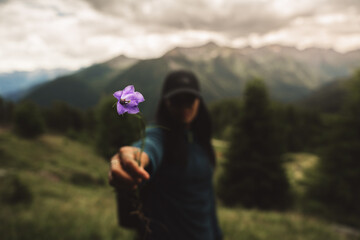 Girl holding a purple flower in the mountains
