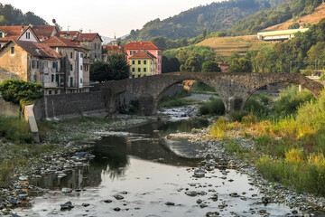 Fototapeta na wymiar Ancient medieval bridge, in stone arch, over small river, commune of Campo Ligure, Liguria region, Genoa province, Italy