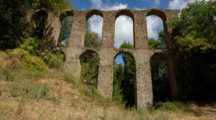 Fototapeta na wymiar The 17th century aqueduct of Monterano Natural Reserve.A ghost medieval city in the country of Lazio region province of Rome,Monterano, born in Etruscan times on top of a small tuff hill,Italy