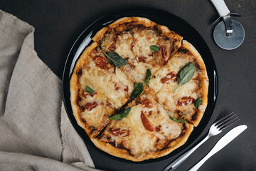evening meal, Italian pizza, black olives, mozzarella cheese and fresh basil on a wooden background, close up