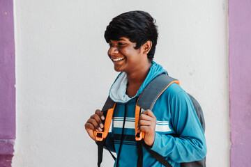 Portrait of an Indian kid wearing backpack looking sideways