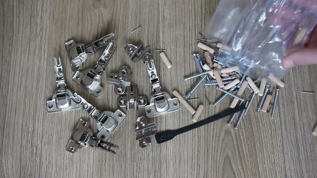 Furniture fittings. A set of mounting fasteners for furniture assembly. Overhead hinge, dowels and screws.
