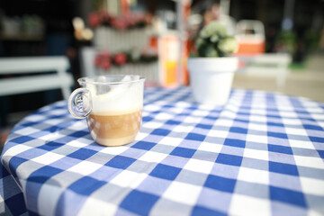 Cappuccino in glass on he table outside. Nobody.