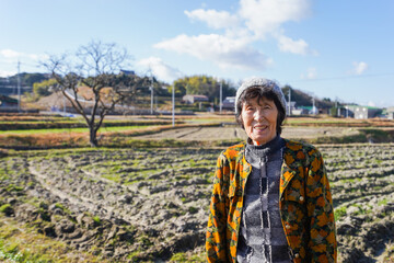 田舎でほほえむ高齢の女性