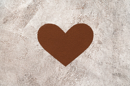 Heart shape of spreading cocoa powder onc oncrete background